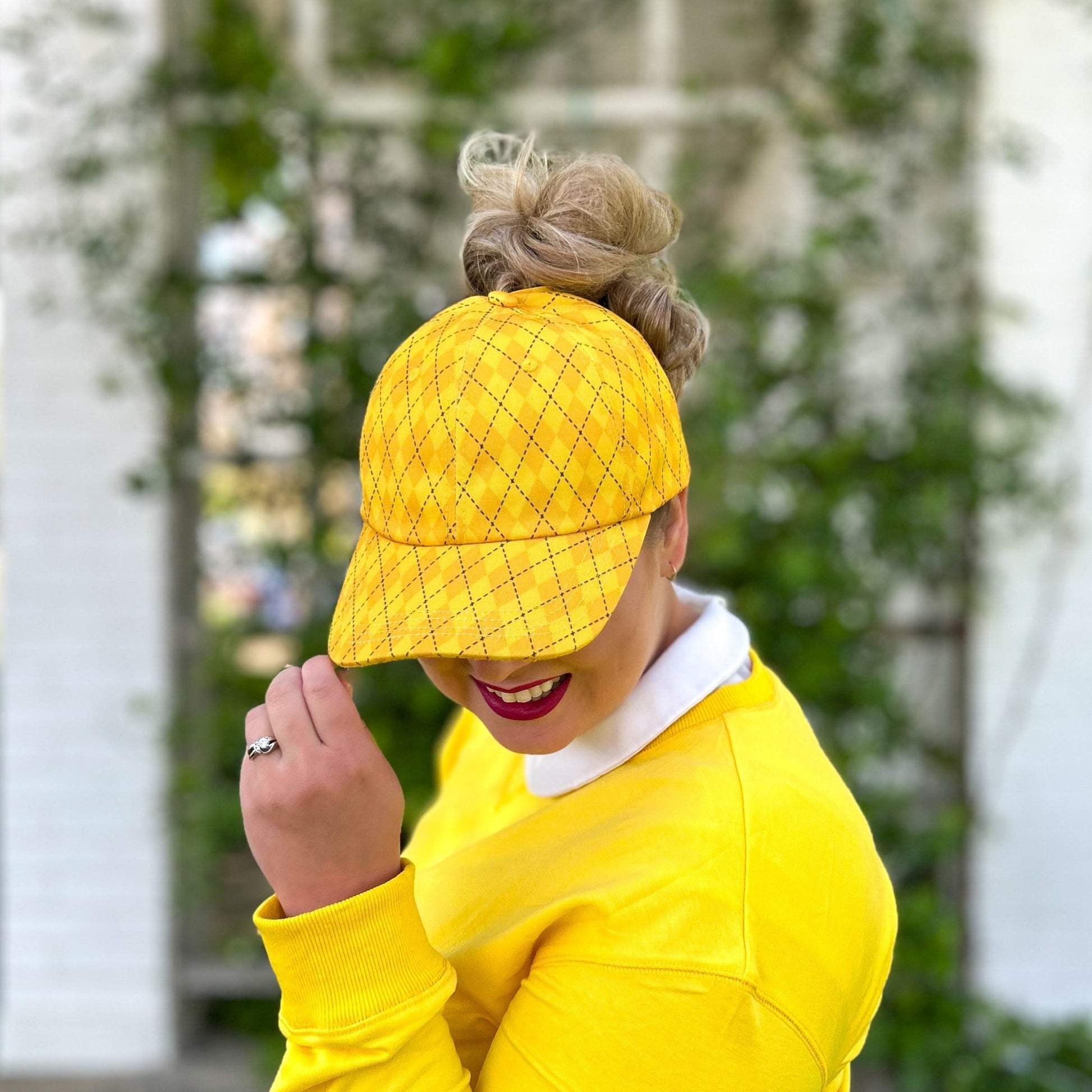 front view of yellow messy bun baseball cap, red sprite hats, diamond yellow hat, harry potter ponytail cap, hogwarts house baseball cap, hufflepuff hat, women's harry potter look, potter bounding, theme park hat