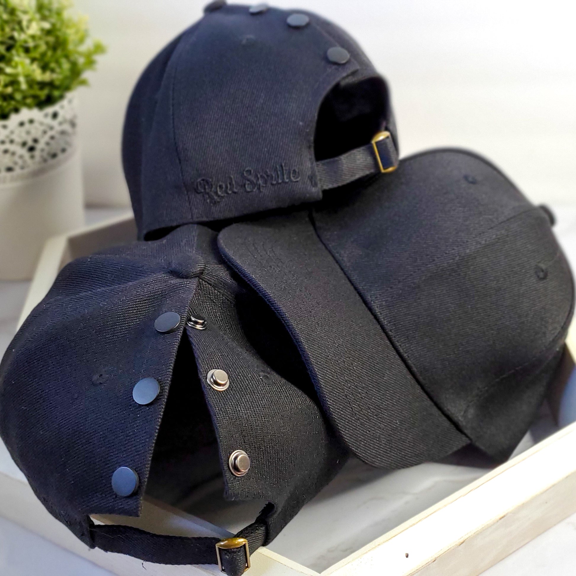image of 3 classic black red sprite hats. showing front and hidden opening back of hats