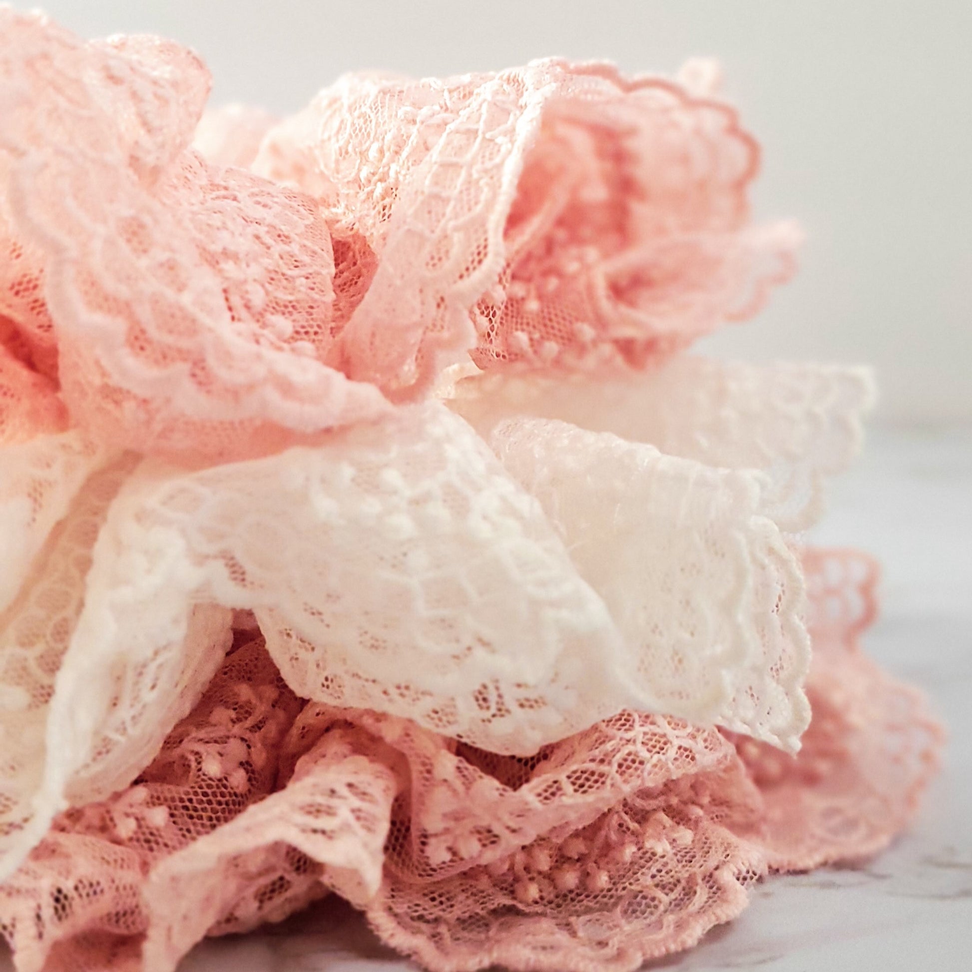 detail closeup of fancy lace scrunchies white and light pink red sprite hats