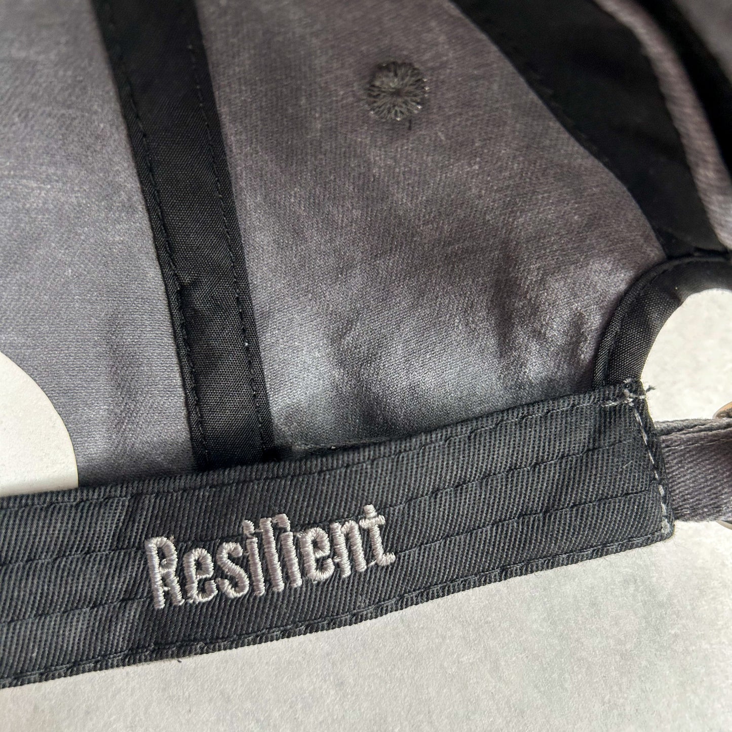 inside view of stormy grey women's baseball cap with the word Resilient embroidered on hat