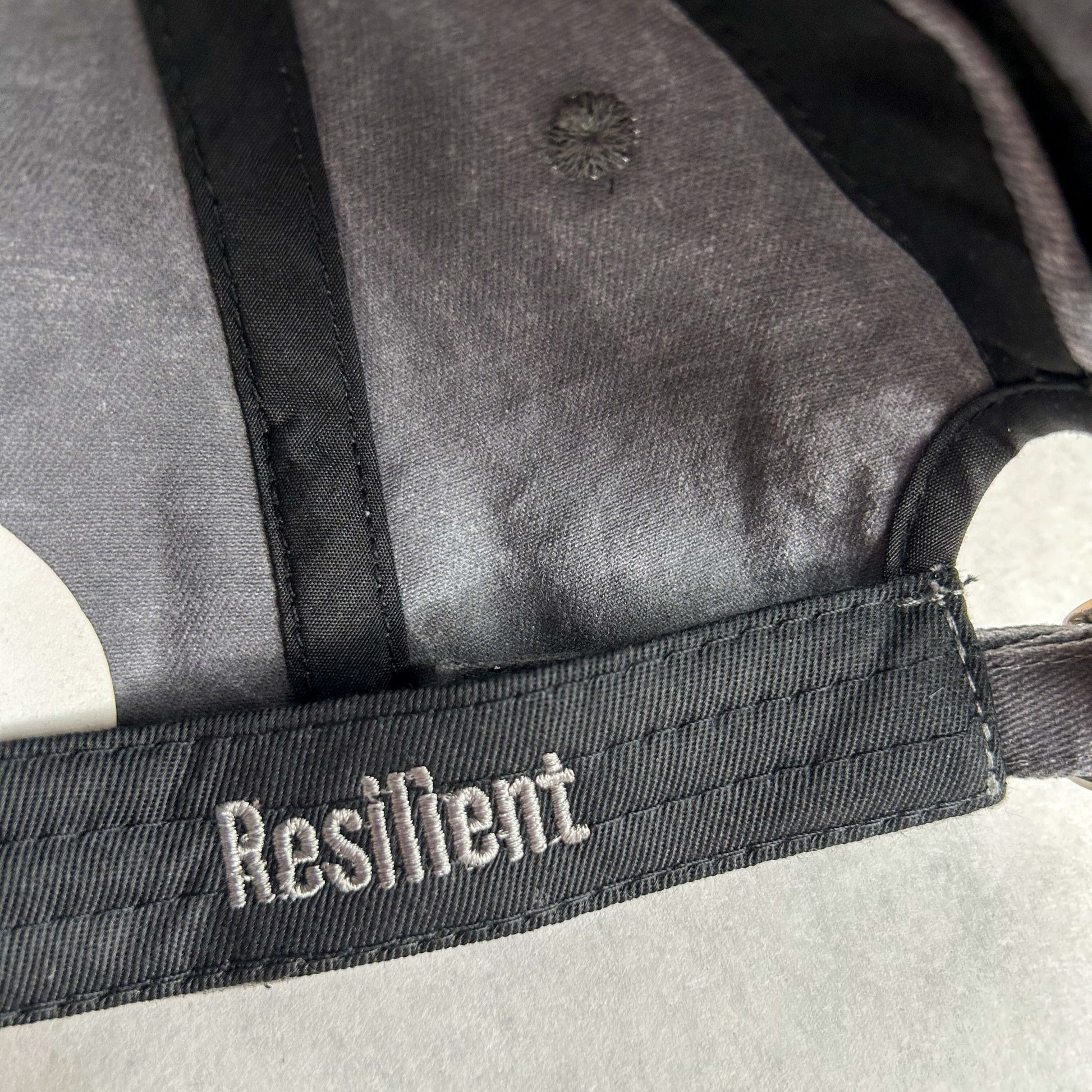 inside view of stormy grey women's baseball cap with the word Resilient embroidered on hat