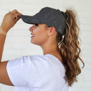 side view of dark grey distressed messy bun baseball cap with curly high ponytail red sprite hats 