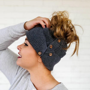 side view of dark grey button-up beanie with high messy bun red sprite hats
