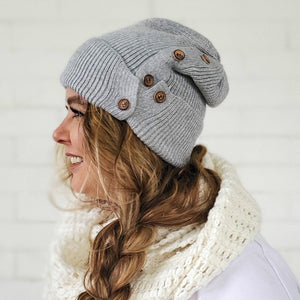 side view of female wearing heather grey button up beanie with long messy side braid