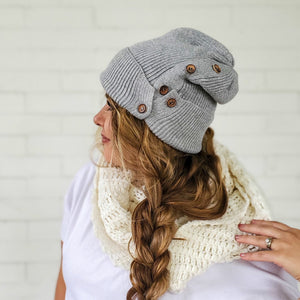 female with long messy side braid wearing heather grey button up beanie