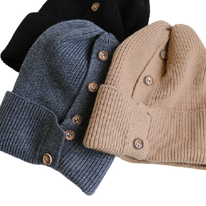3 button-up beanies laid down with buttons facing up: light mocha brown beanie, dark grey, and black beanies